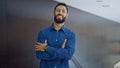 Young hispanic man business worker standing with arms crossed gesture at the office Royalty Free Stock Photo