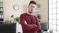 Young hispanic man business worker standing with arms crossed gesture and serious face at office Royalty Free Stock Photo