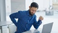 Young hispanic man business worker taking glasses off suffering for backache at the office Royalty Free Stock Photo