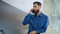 Young hispanic man business worker talking on smartphone smiling at the office Royalty Free Stock Photo