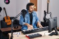 Young hispanic man composer composing song at music studio Royalty Free Stock Photo