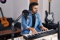 Young hispanic man composer composing song at music studio Royalty Free Stock Photo