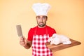 Young hispanic man cooking chicken holding knife depressed and worry for distress, crying angry and afraid Royalty Free Stock Photo