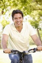 Young Hispanic Man Cycling In Park Royalty Free Stock Photo