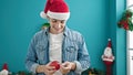 Young hispanic man decorating christmas tree at home Royalty Free Stock Photo