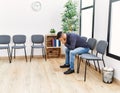 Young hispanic man desperate sitting on chair at waiting room Royalty Free Stock Photo