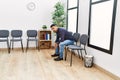 Young hispanic man desperate sitting on chair at waiting room Royalty Free Stock Photo