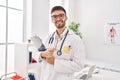 Young hispanic man doctor smiling confident holding clipboard at clinic Royalty Free Stock Photo