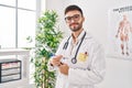 Young hispanic man doctor smiling confident holding clipboard at clinic Royalty Free Stock Photo