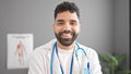 Young hispanic man doctor smiling confident standing at clinic Royalty Free Stock Photo