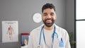 Young hispanic man doctor smiling confident standing at clinic Royalty Free Stock Photo