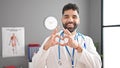 Young hispanic man doctor smiling doing heart gesture with hands at clinic Royalty Free Stock Photo