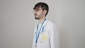 Young hispanic man doctor standing with serious expression from the side over isolated white background Royalty Free Stock Photo