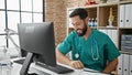Young hispanic man doctor using computer working at the clinic Royalty Free Stock Photo