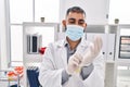 Young hispanic man doctor wearing medical mask wearing gloves at clinic Royalty Free Stock Photo