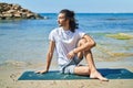 Young hispanic man doing yoga exercise sitting on sand at beach Royalty Free Stock Photo