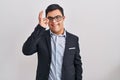 Young hispanic man with down syndrome wearing business style doing ok gesture with hand smiling, eye looking through fingers with Royalty Free Stock Photo