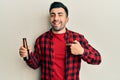 Young hispanic man drinking a bottle of beer pointing finger to one self smiling happy and proud Royalty Free Stock Photo