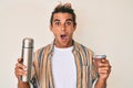 Young hispanic man drinking mate infusion afraid and shocked with surprise and amazed expression, fear and excited face Royalty Free Stock Photo