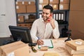 Young hispanic man e-commerce business worker talking on the smartphone at office Royalty Free Stock Photo
