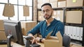 Young hispanic man ecommerce business looking serious at the camera at office Royalty Free Stock Photo