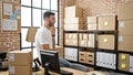 Young hispanic man ecommerce business worker sitting with serious face at office Royalty Free Stock Photo