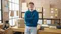 Young hispanic man ecommerce business worker standing with arms crossed gesture smiling at office Royalty Free Stock Photo