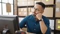 Young hispanic man ecommerce business worker thinking at office Royalty Free Stock Photo
