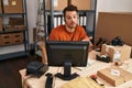 Young hispanic man ecommerce call center agent having video call writing on notebook at office Royalty Free Stock Photo