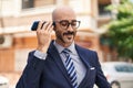 Young hispanic man executive listening audio message by smartphone at street Royalty Free Stock Photo