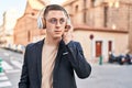 Young hispanic man executive listening to music at street Royalty Free Stock Photo