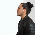 Young hispanic man with gathered hair done bow in black dress and black leather jacket