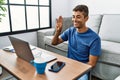 Young hispanic man gesturing sign language on video call at home Royalty Free Stock Photo