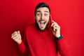 Young hispanic man having conversation talking on the smartphone screaming proud, celebrating victory and success very excited Royalty Free Stock Photo