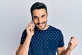 Young hispanic man having conversation talking on the smartphone screaming proud, celebrating victory and success very excited Royalty Free Stock Photo