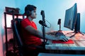 Young Hispanic man with headphones sitting at a desk and looking at the computer screen. Royalty Free Stock Photo
