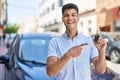 Young hispanic man holding car key smiling happy pointing with hand and finger Royalty Free Stock Photo