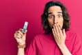 Young hispanic man holding computer memory covering mouth with hand, shocked and afraid for mistake Royalty Free Stock Photo