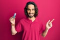 Young hispanic man holding computer memory smiling happy pointing with hand and finger to the side Royalty Free Stock Photo