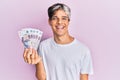 Young hispanic man holding russian 500 ruble banknotes looking positive and happy standing and smiling with a confident smile