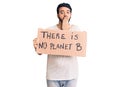 Young hispanic man holding there is no planet b banner covering mouth with hand, shocked and afraid for mistake Royalty Free Stock Photo