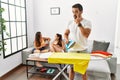 Young hispanic man ironing clothes at home pointing to the eye watching you gesture, suspicious expression Royalty Free Stock Photo