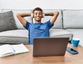 Young hispanic man listening to music on laptop at home Royalty Free Stock Photo