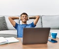 Young hispanic man listening to music on laptop at home Royalty Free Stock Photo