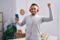 Young hispanic man listning to music and dancing at bedroom Royalty Free Stock Photo