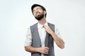 Young hispanic man loosing tie on grey background. He is feeling that can not breathe. Royalty Free Stock Photo