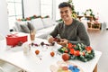 Young hispanic man make handsmade christmas decoration at home Royalty Free Stock Photo