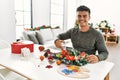 Young hispanic man make handsmade christmas decoration at home Royalty Free Stock Photo