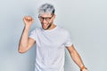 Young hispanic man with modern dyed hair wearing white t shirt and glasses dancing happy and cheerful, smiling moving casual and Royalty Free Stock Photo