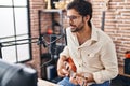 Young hispanic man musician singing song playing ukulele at music studio Royalty Free Stock Photo